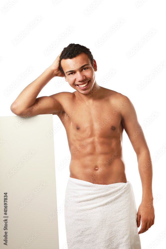 A nude young man covering himself with a towel A nude young man covering himself with a towel