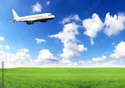 Airplane flying above green field
