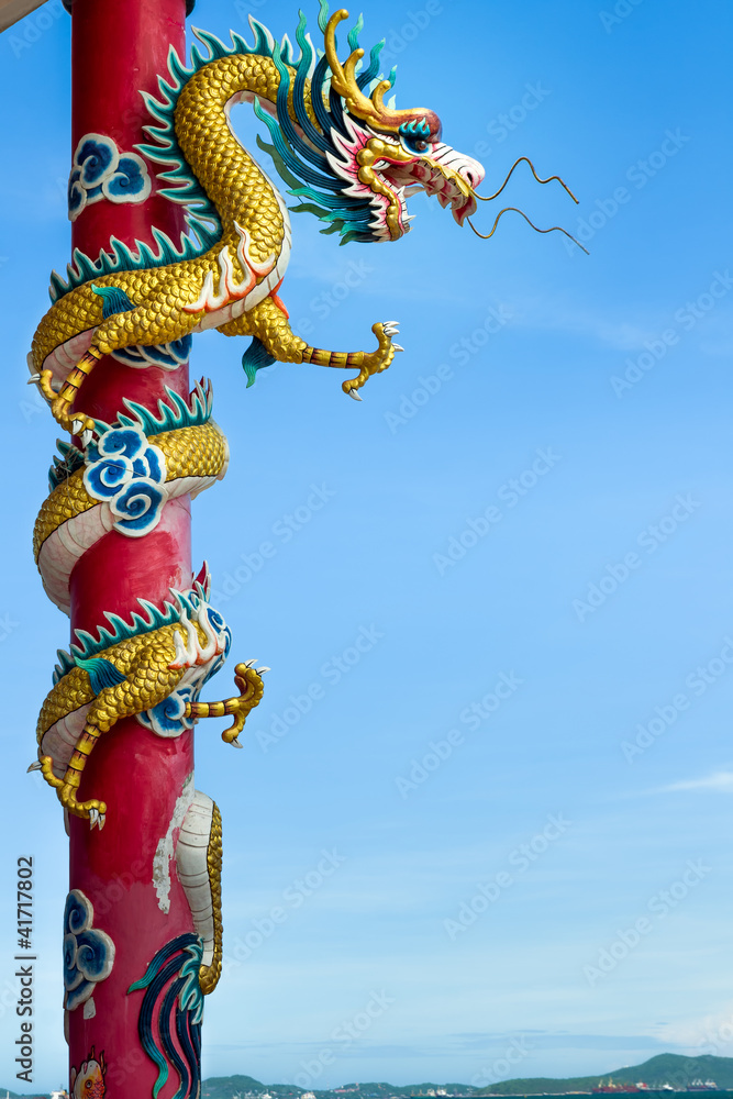 Fototapeta premium Golden dragon wrapped around red pole