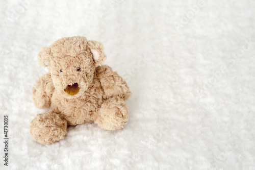 teddy bear seated on white carpet © aldegonde le compte