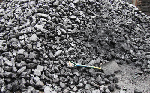 A Large Pile of Coal with a Shovel.