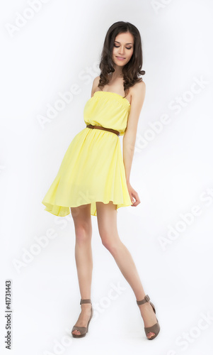 Wallpaper Mural Trendy young woman in yellow dress smiling on white background Torontodigital.ca