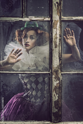 Valokuva A lonely pierrot woman behind the glass