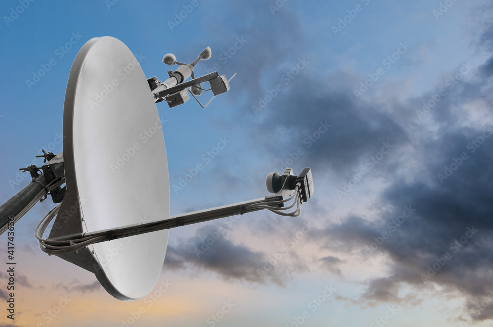 satellite rooftop dish with wind meter and dramatic cloudy sky
