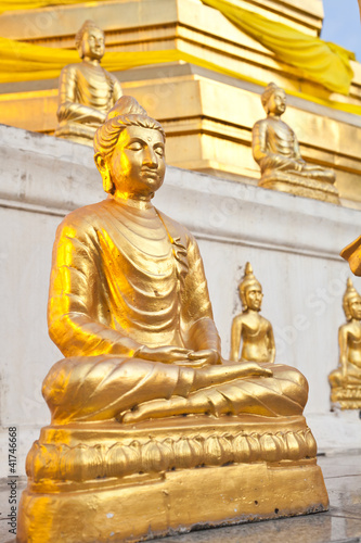 Gold buddha in front of gold pagoda