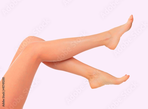 Well-groomed female legs on pink background