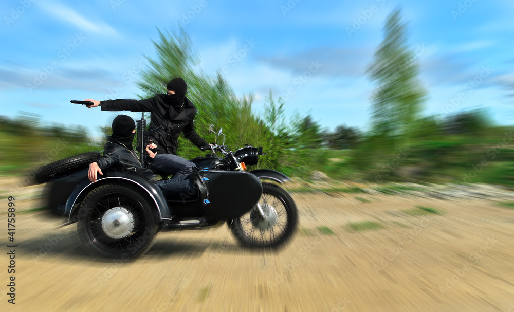 Two armed men riding a motorcycle with a sidecar. Motion blur. Two armed men riding a motorcycle with a sidecar. Motion blur.
