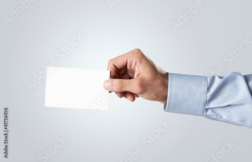 Male hand passing blank business card with copy space