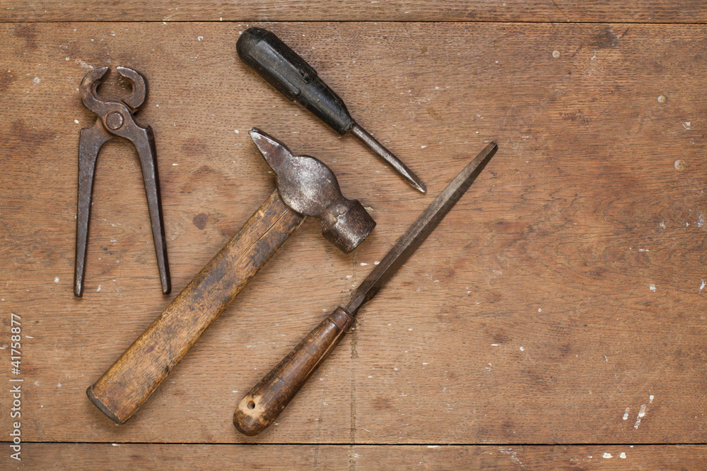 Old hammer, pincers, rasp on grunge wood background Old hammer, pincers, rasp on grunge wood background