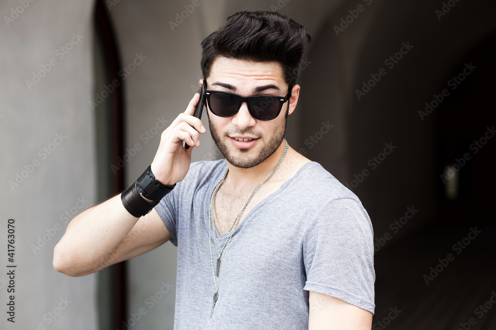 handsome young man talking on a smartphone handsome young man talking on a smartphone