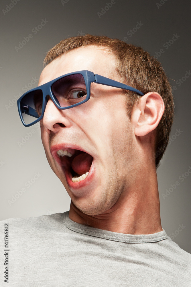 Young man in sun glasses with surprised smile Young man in sun glasses with surprised smile