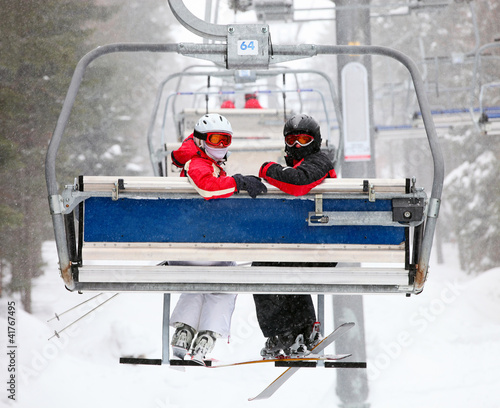 Skiers on a ski-lift photo