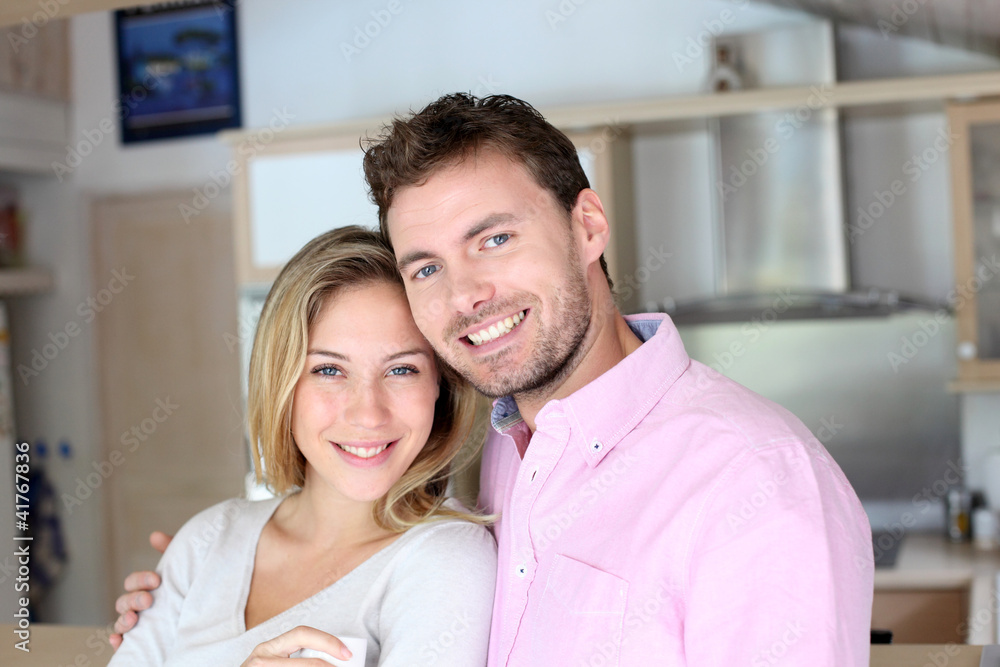 Portrait of in love couple standing in home kitchen Portrait of in love couple standing in home kitchen