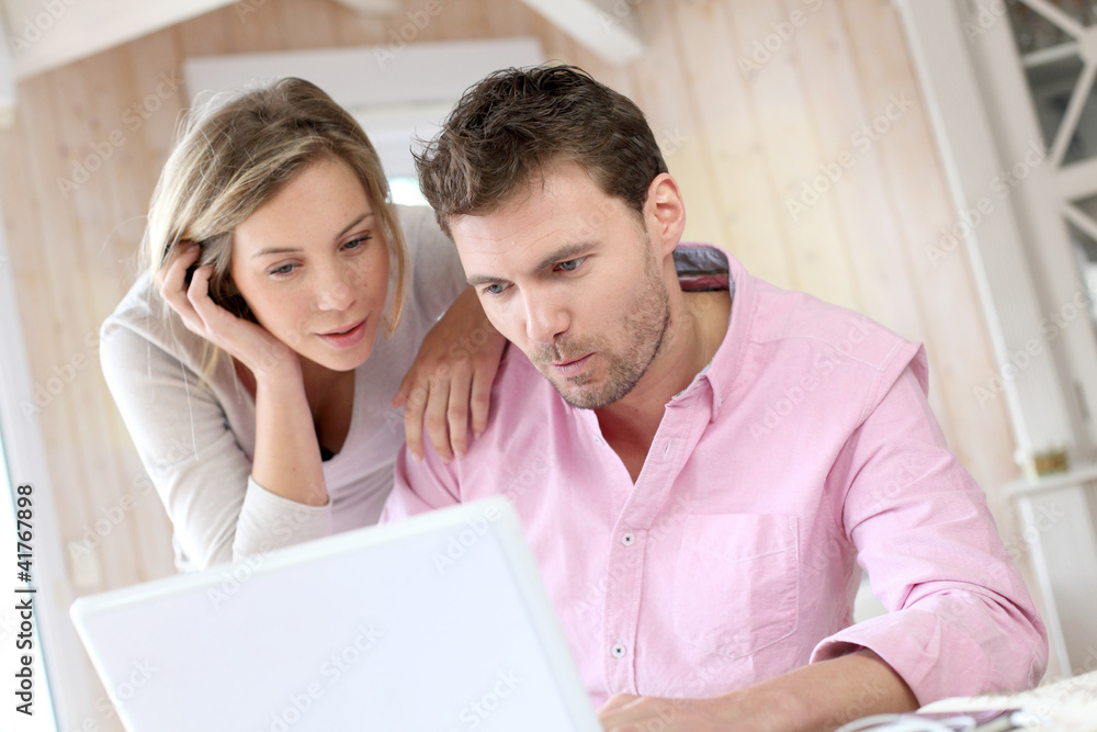 Couple at home using laptop computer Couple at home using laptop computer