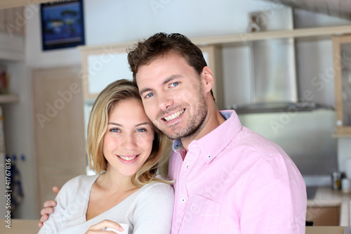 Portrait of in love couple standing in home kitchen
