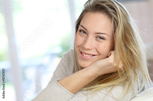 Attractive young blond woman relaxing in sofa