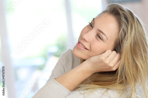 Attractive young blond woman relaxing in sofa