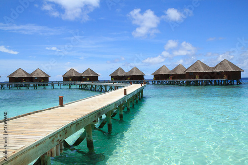 Long wooden bridge and water villas Maldives