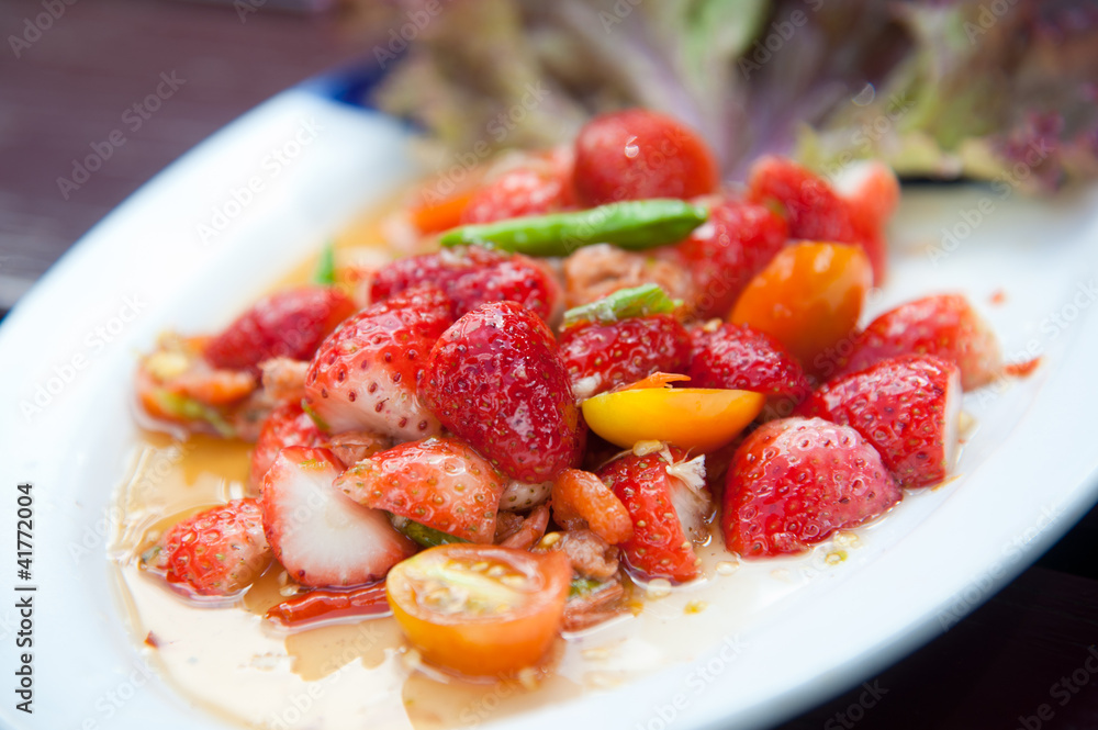 Strawberries spicy salad with chili, tomatoes and vegetables