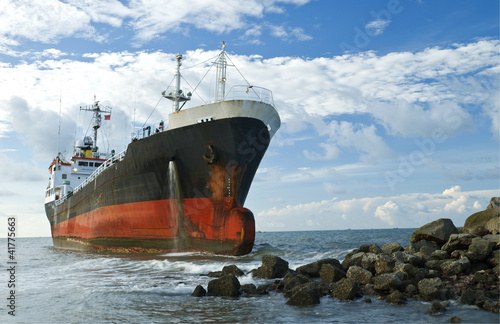 фотографія Cargo ship run aground on rocky shore shore
