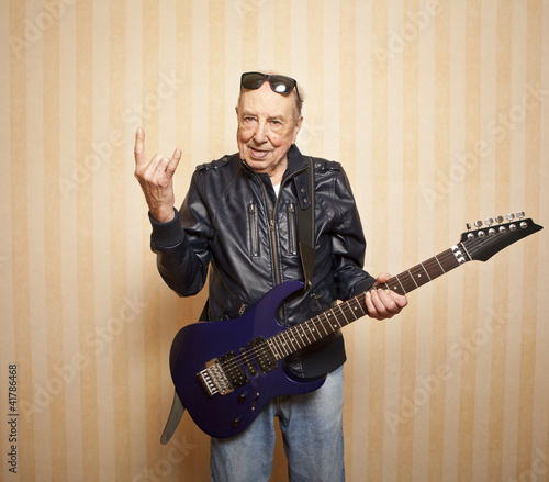 cool fashion elder man with electric guitar photo