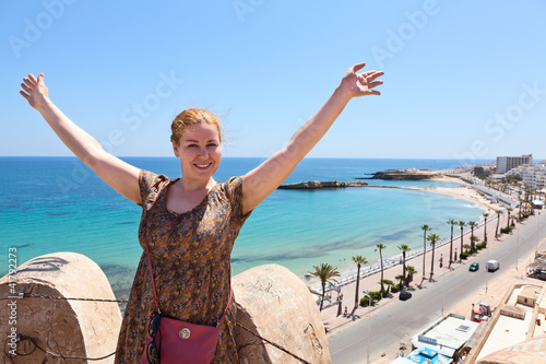 Happy woman on ancient tower of fortress with beauty view behind