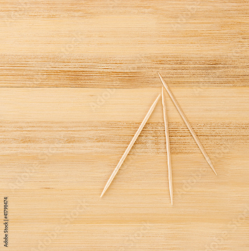three toothpicks on a wooden table