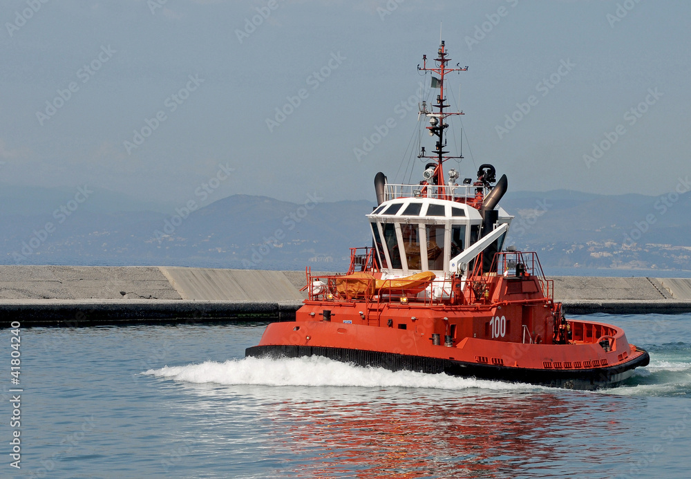 Un rimorchiatore in navigazione lungo la diga foranea Un rimorchiatore in navigazione lungo la diga foranea