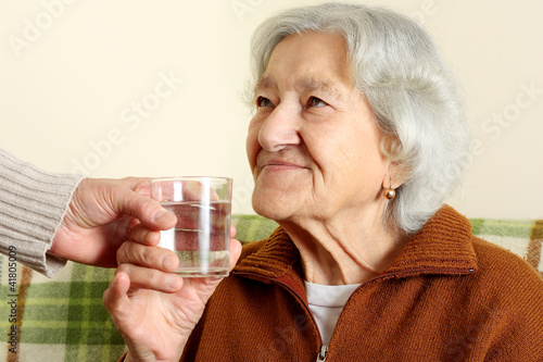 Grandmother drinks a glass water