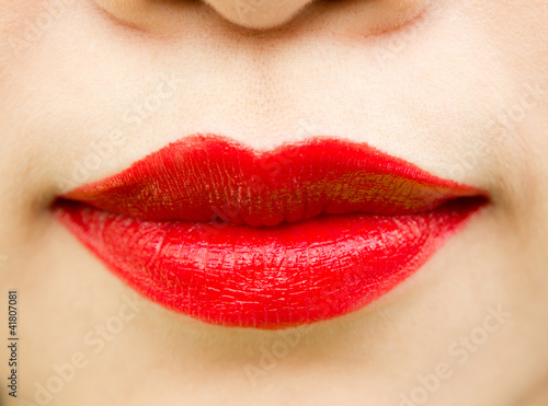 Close-up shot of woman lips with glossy red lipstick