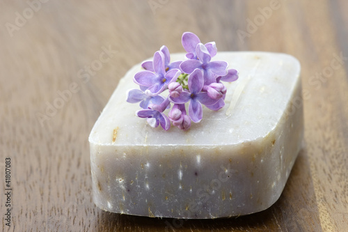 bar of natural soap and lilac flowers