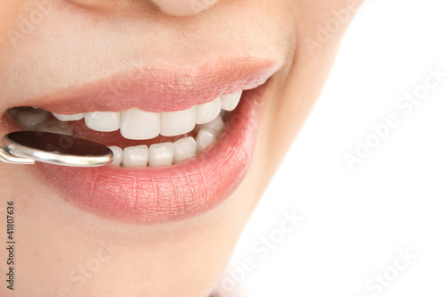 Healthy woman teeth and a dentist mouth mirror