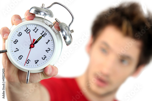 Young man with an alarm clock