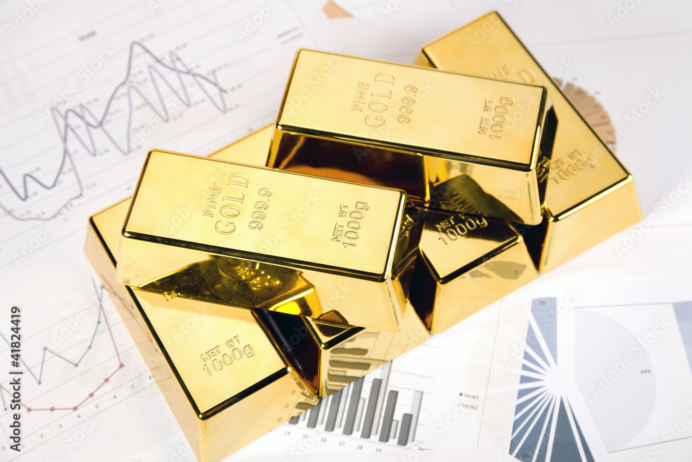 Photo of gold bars on graphs and statistics, studio shots Photo of gold bars on graphs and statistics, studio shots