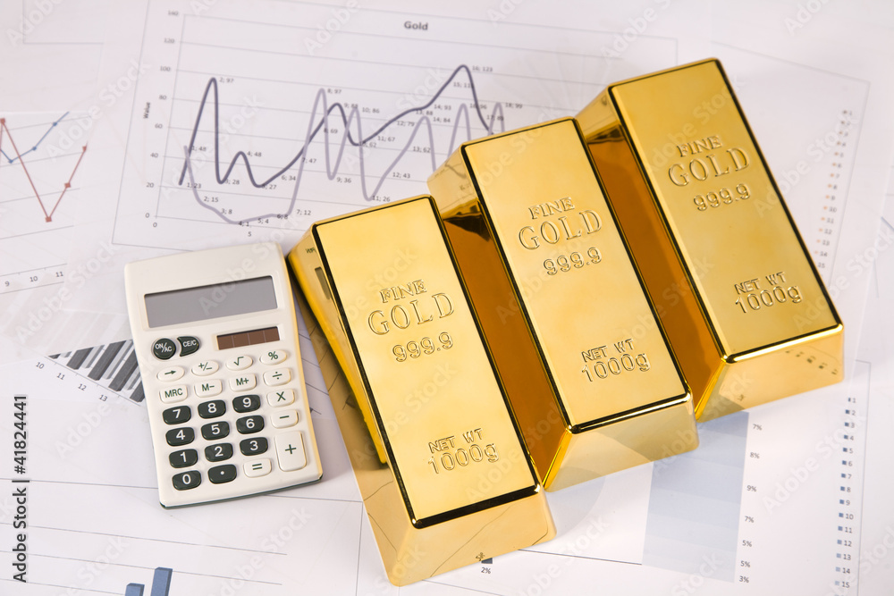 Photo of gold bars on graphs and statistics, studio shots Photo of gold bars on graphs and statistics, studio shots