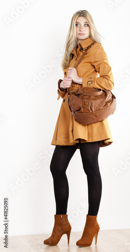 standing woman wearing coat and fashionable brown shoes with a h © Richard Semik