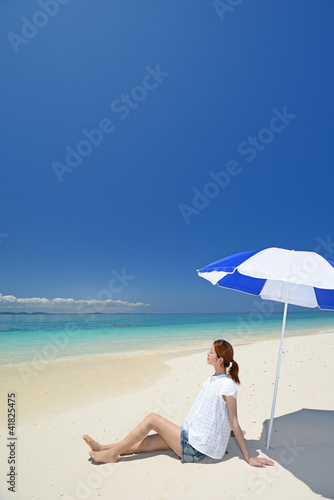 南国沖縄の綺麗なビーチで寛ぐ女性 © sunabesyou