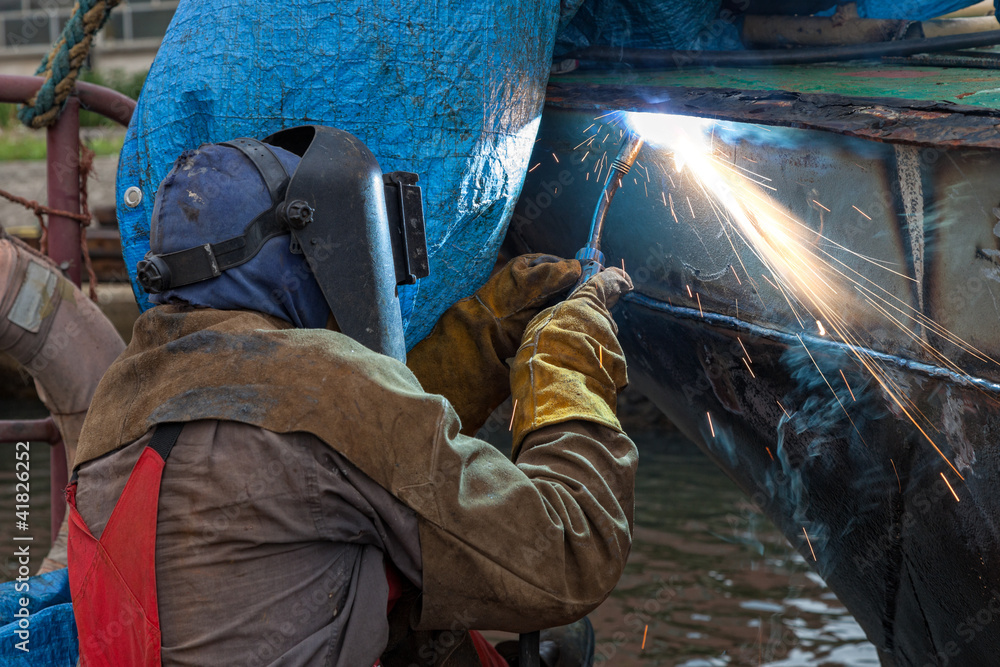 Welder in a protective mask when working. Welder in a protective mask when working.