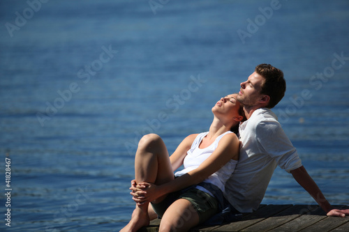Couple relaxing on a lake bridge in summertime © goodluz
