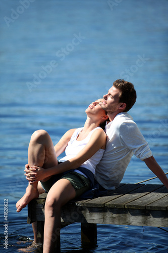 Couple relaxing on a lake bridge in summertime © goodluz