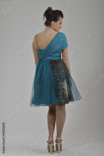 elegant woman in fashionable dress posing in the studio