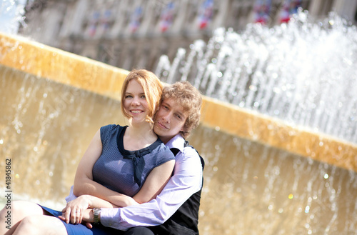 Young loving couple and beautiful fountain water jets photo