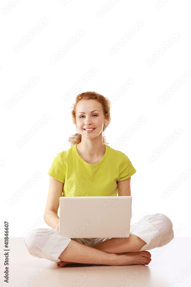A young girl sitting on the floor with a laptop A young girl sitting on the floor with a laptop