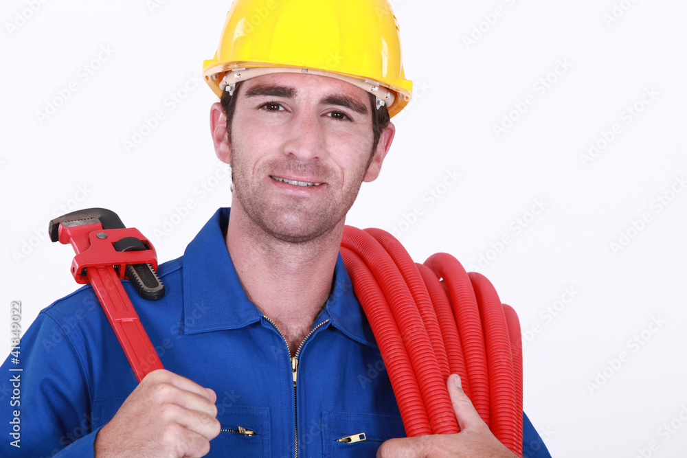 portrait of cheerful plumber carrying hose and spanner portrait of cheerful plumber carrying hose and spanner