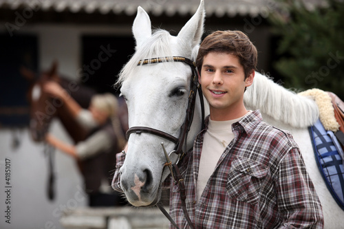 Young man looking after horses