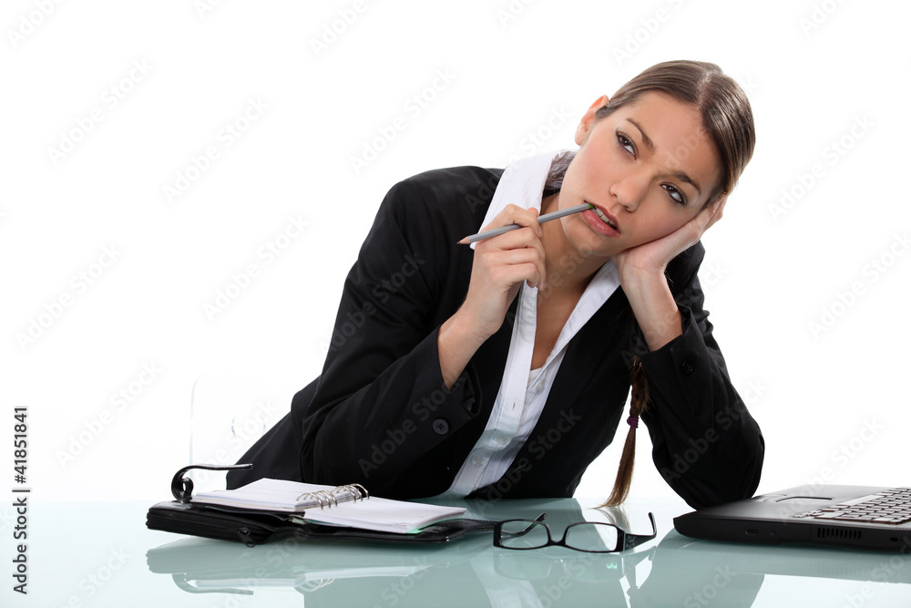 Pensive businesswoman sitting at a desk Pensive businesswoman sitting at a desk