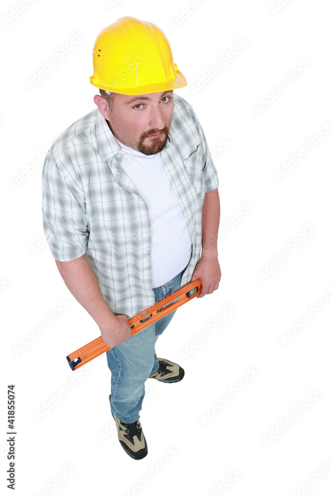 Grumpy manual worker holding spirit-level Grumpy manual worker holding spirit-level