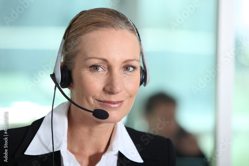 Obraz na plátně Woman smiling with headset