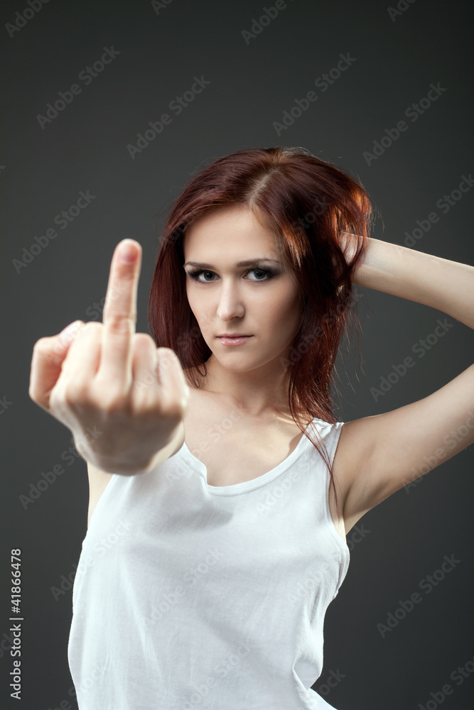 Anger young woman in tank top with fuck sign Anger young woman in tank top with fuck sign