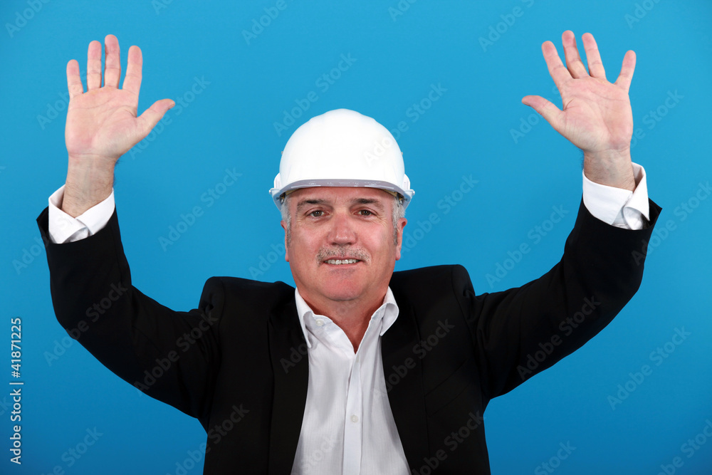 A mature architect rising his hands.
